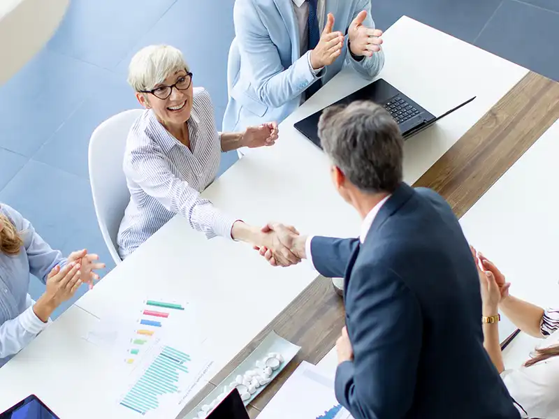 Two people shaking hands during a meeting